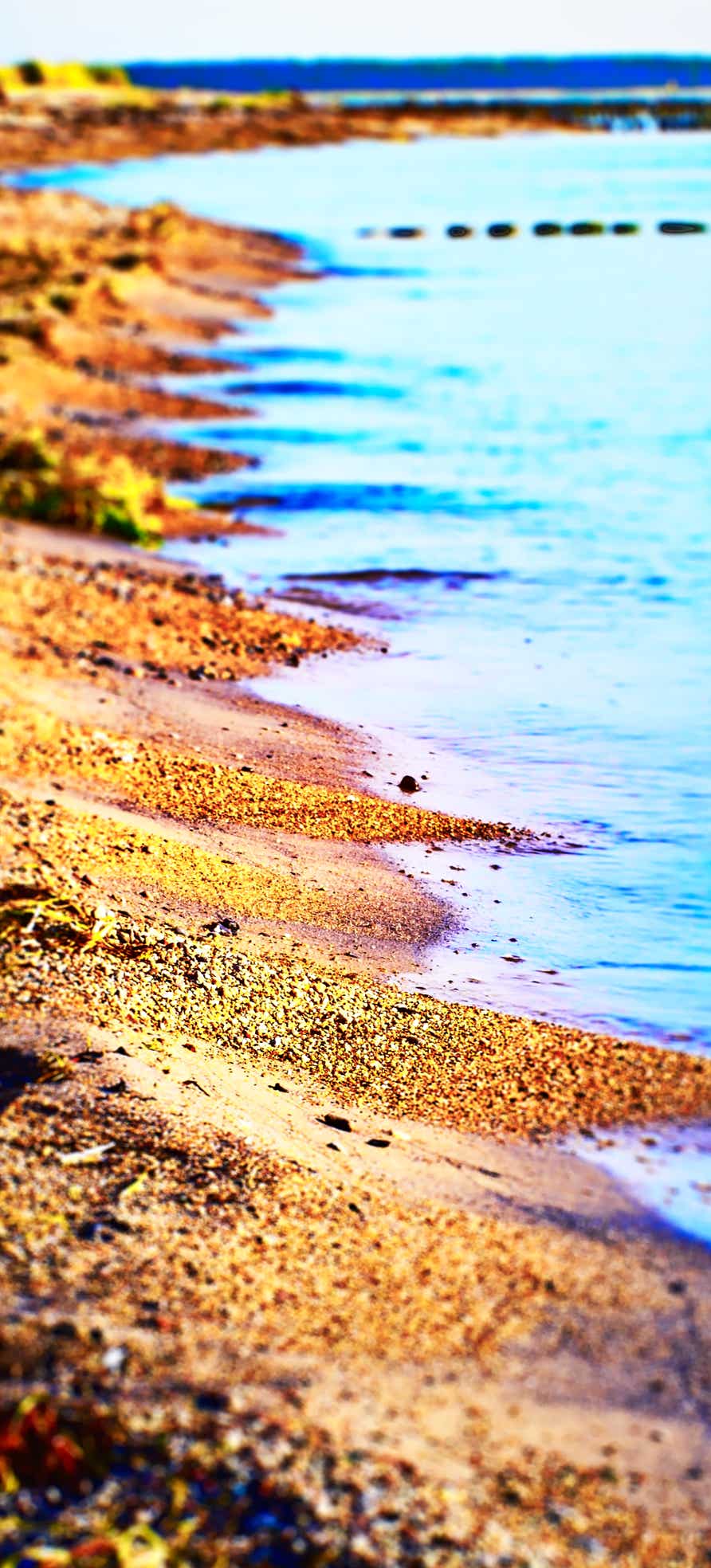 Teleaufnahme Wasserkante Strand mit Weitblick